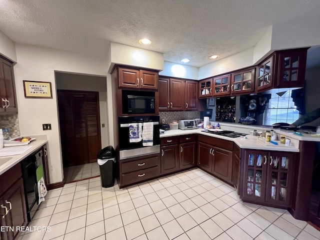 kitchen with light tile patterned flooring, decorative backsplash, dark brown cabinets, and black appliances