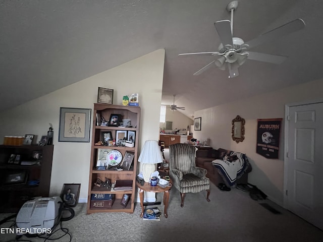 living area with ceiling fan, vaulted ceiling, and carpet