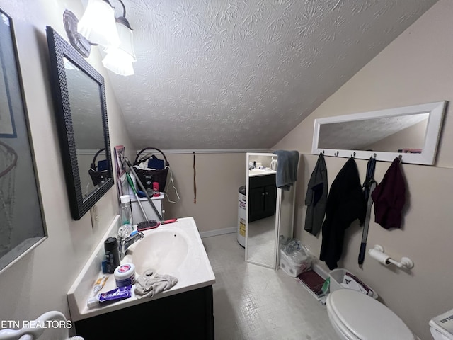 bathroom with vanity, lofted ceiling, a textured ceiling, and toilet