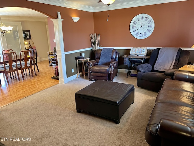 living room featuring ornamental molding, carpet flooring, a chandelier, and ornate columns