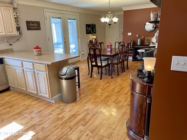 kitchen featuring hanging light fixtures, ornamental molding, light hardwood / wood-style floors, and kitchen peninsula