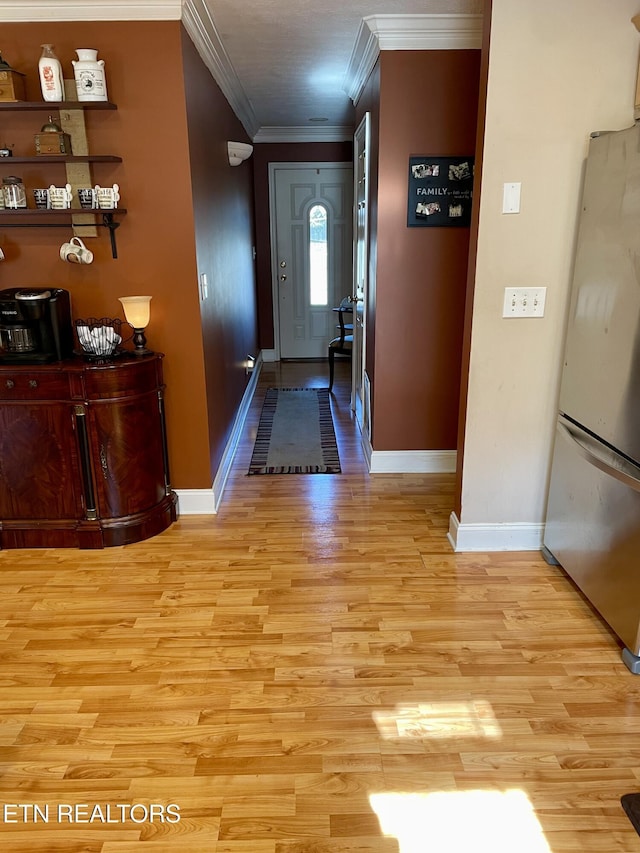 entryway featuring crown molding and light hardwood / wood-style floors