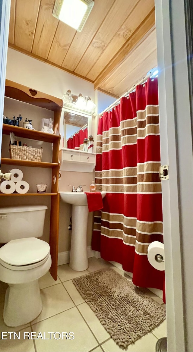 bathroom with tile patterned floors, wooden ceiling, and toilet