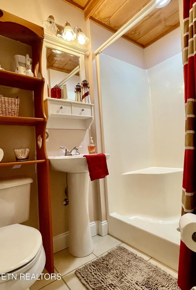 bathroom with curtained shower, tile patterned floors, and toilet