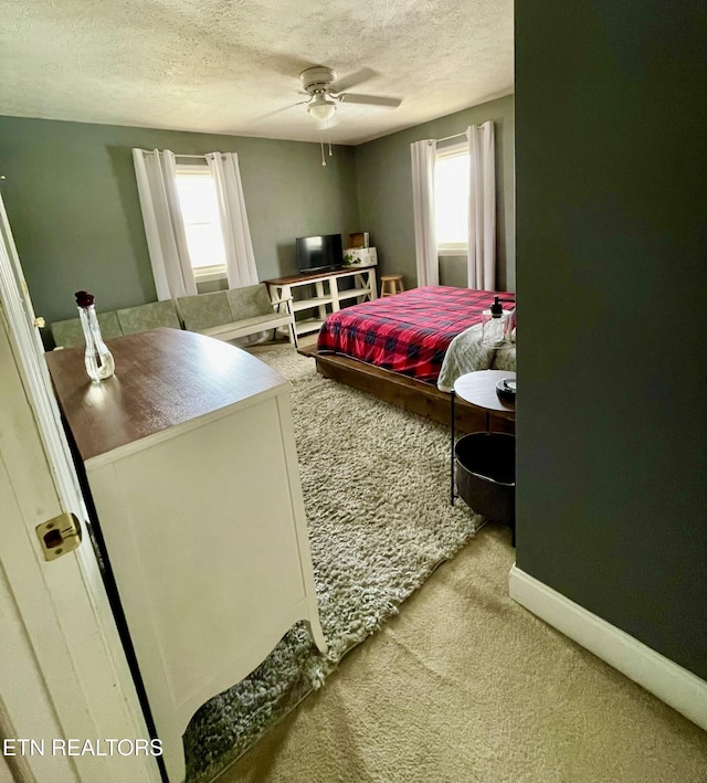 bedroom featuring ceiling fan, carpet floors, and a textured ceiling