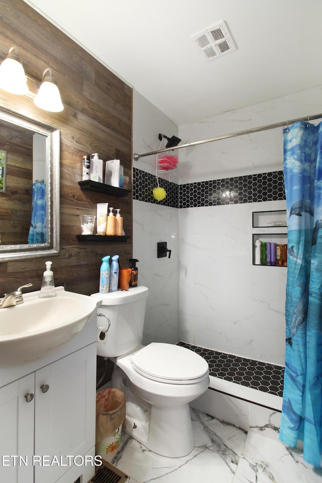 bathroom featuring vanity, walk in shower, toilet, and wood walls