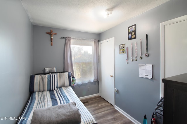 bedroom with hardwood / wood-style flooring and a textured ceiling