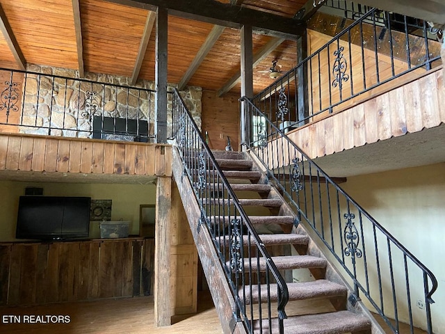 stairs featuring beamed ceiling, wood-type flooring, and wooden ceiling