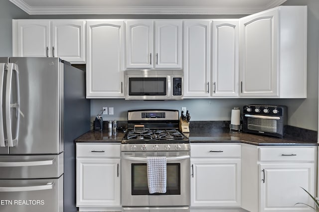 kitchen featuring a toaster, appliances with stainless steel finishes, white cabinetry, and crown molding