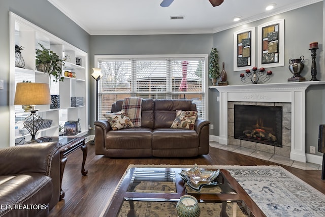 living area featuring crown molding, a fireplace, visible vents, and wood finished floors