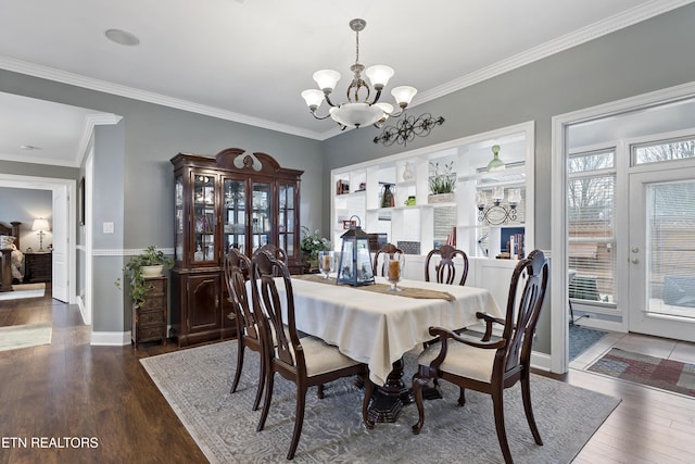 dining space with a notable chandelier, hardwood / wood-style floors, baseboards, and crown molding