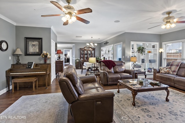 living area with ornamental molding, ceiling fan with notable chandelier, baseboards, and wood finished floors