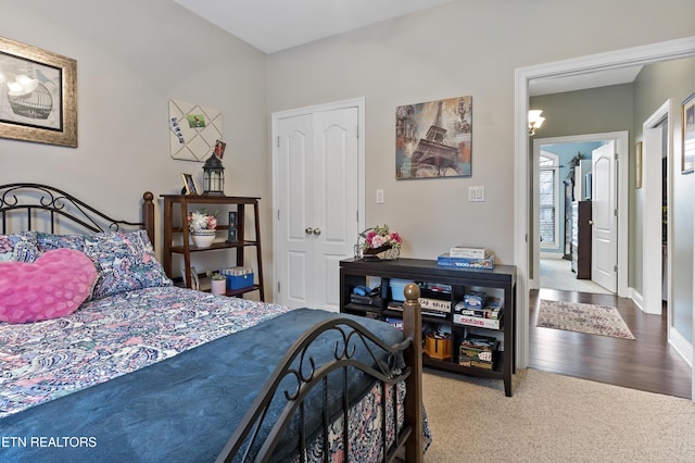 carpeted bedroom with baseboards and wood finished floors