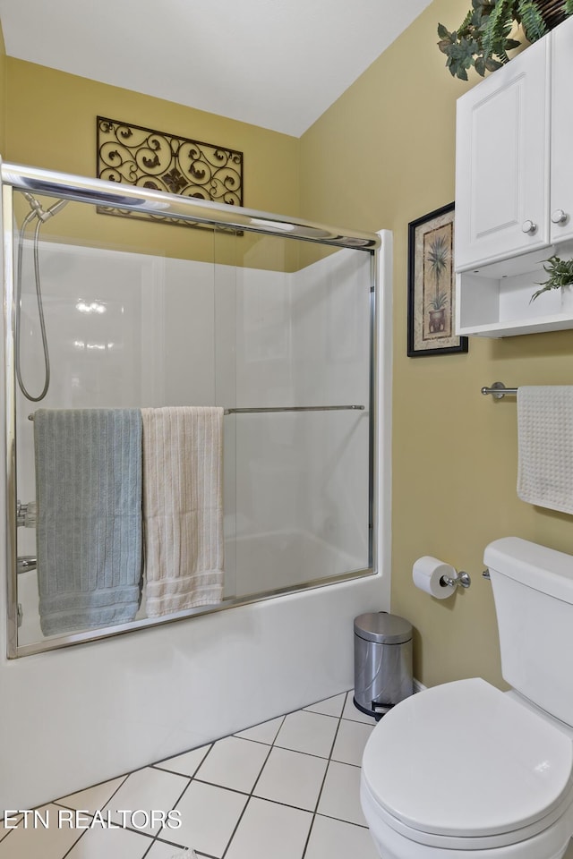 full bath featuring bath / shower combo with glass door, toilet, and tile patterned floors