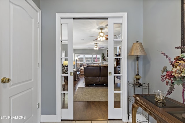 interior space with a ceiling fan, french doors, and wood finished floors