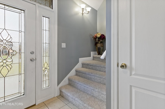 foyer entrance with light tile patterned floors and stairs