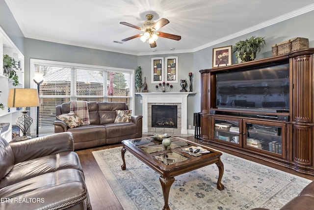 living room featuring ornamental molding, a tile fireplace, visible vents, and hardwood / wood-style floors