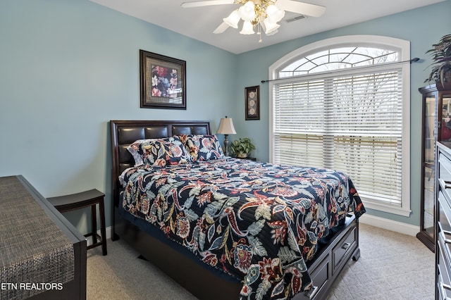 bedroom featuring a ceiling fan, light carpet, visible vents, and baseboards