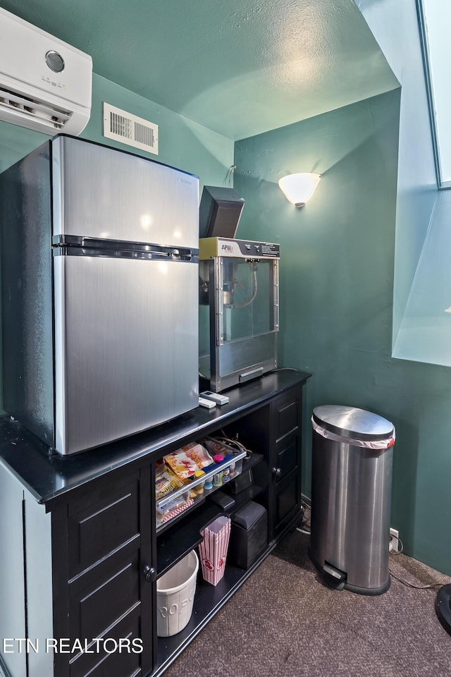 interior space with visible vents, a textured ceiling, and a wall mounted air conditioner