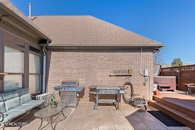 view of patio featuring an outdoor living space with a fire pit, grilling area, fence, and a hot tub