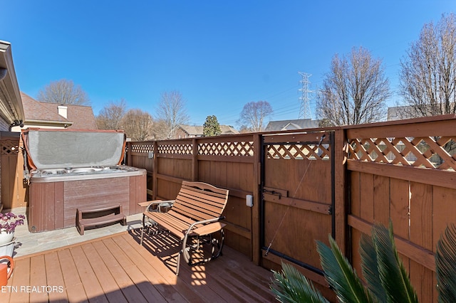 wooden terrace with a hot tub and fence