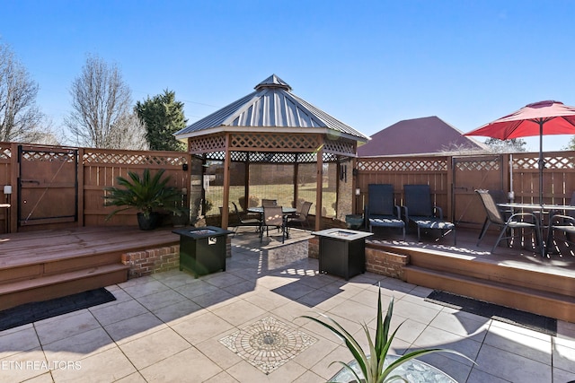 view of patio / terrace with a gazebo, an outdoor fire pit, a fenced backyard, and outdoor dining space