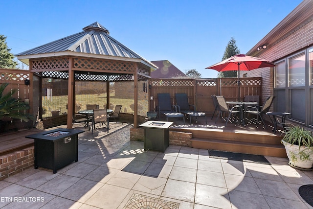 view of patio featuring an outdoor fire pit, outdoor dining area, and a gazebo