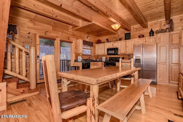 dining room featuring light wood-type flooring, wood ceiling, and wood walls