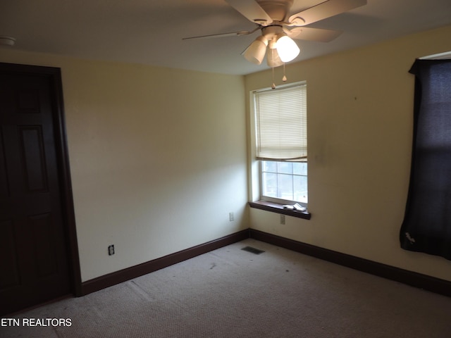 carpeted spare room featuring ceiling fan