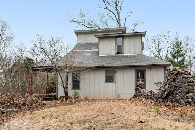 rear view of property featuring roof with shingles