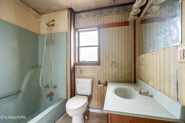 bathroom with bathing tub / shower combination, toilet, vanity, and wallpapered walls