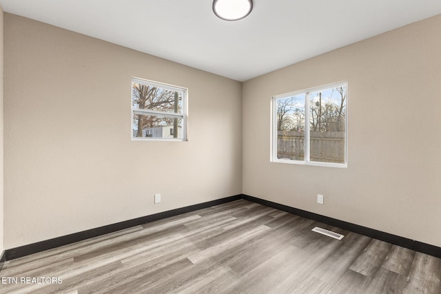 unfurnished room featuring plenty of natural light and light hardwood / wood-style floors