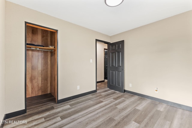 unfurnished bedroom with hardwood / wood-style floors and a closet