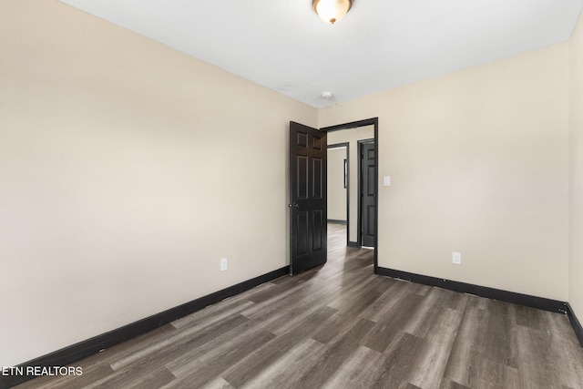 spare room with dark wood-type flooring