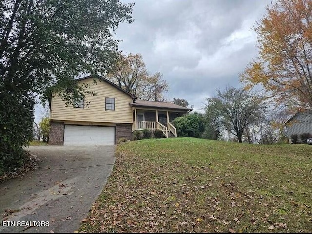 split level home with a garage, covered porch, and a front yard