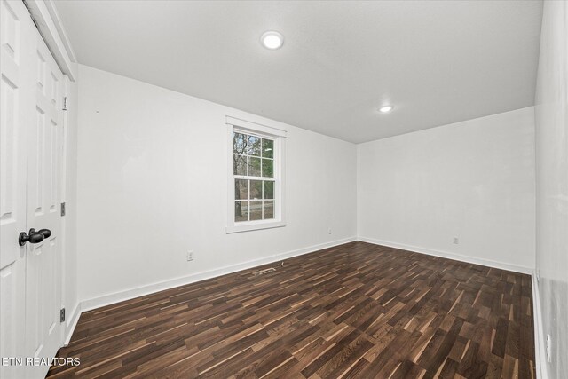 empty room with dark hardwood / wood-style flooring