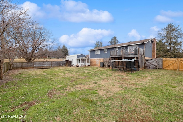 rear view of house with a yard and a deck