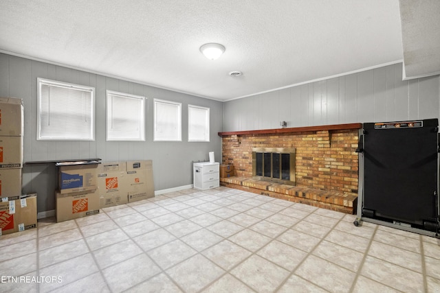 living room featuring a fireplace, ornamental molding, and a textured ceiling