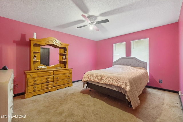 bedroom with ceiling fan, light carpet, and a textured ceiling