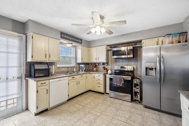 kitchen featuring cream cabinets, decorative backsplash, sink, and appliances with stainless steel finishes