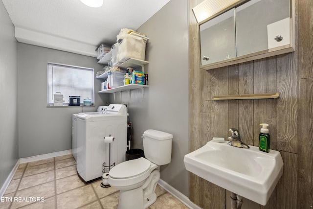 bathroom with sink, tile patterned floors, independent washer and dryer, and toilet