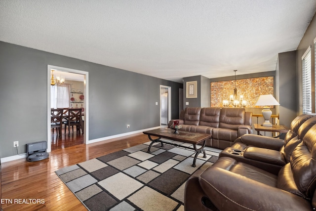 living room featuring hardwood / wood-style floors, a textured ceiling, and a chandelier