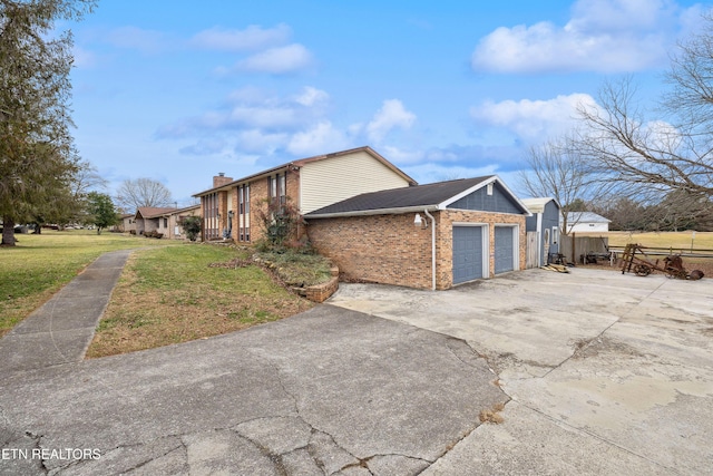 view of side of property with a garage and a lawn