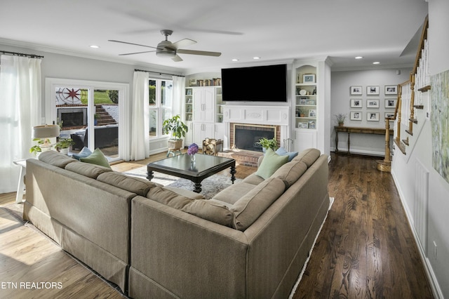 living room with ornamental molding, recessed lighting, a fireplace, and wood finished floors