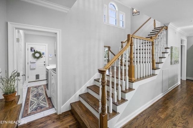 stairway featuring washing machine and dryer, crown molding, and wood finished floors