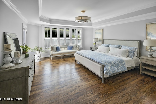 bedroom with dark wood-style floors, ornamental molding, and a raised ceiling