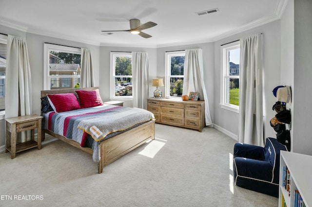 bedroom featuring light colored carpet, visible vents, ornamental molding, a ceiling fan, and baseboards