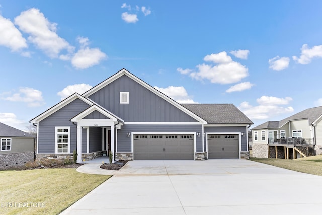 craftsman inspired home featuring a garage and a front lawn