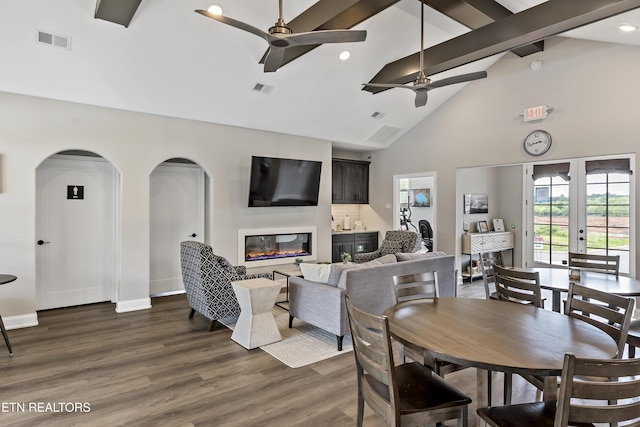 dining area featuring dark hardwood / wood-style flooring, beam ceiling, high vaulted ceiling, and ceiling fan