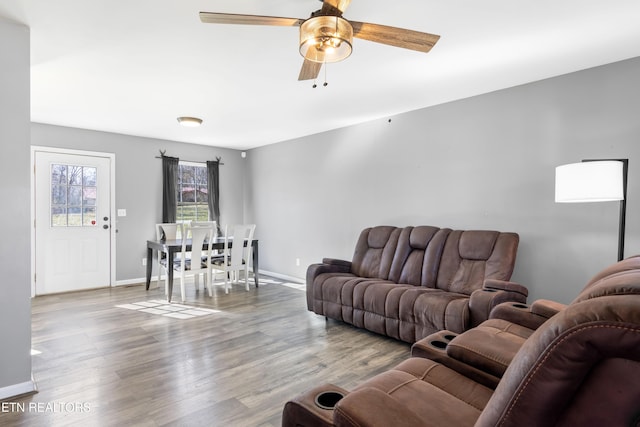 living room with light hardwood / wood-style flooring and ceiling fan